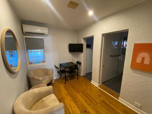 a living room with two couches and a television at Royal Far West Lodge in Sydney