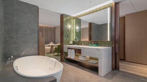 a bathroom with a sink and a large mirror at Holiday Inn Wenzhou Airport by IHG in Wenzhou