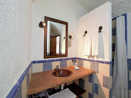 a bathroom with a sink and a mirror at Cave House in Guadix with Private Pool in Bejarín
