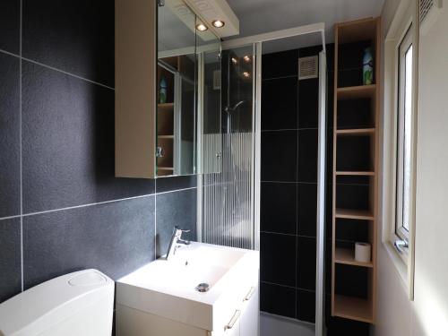 a bathroom with a white sink and a mirror at Beautiful chalet between golf course and beach in Hollum