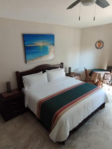 a bedroom with a large bed and a table at Myoli Wellness & Happiness BnB in Playa del Carmen