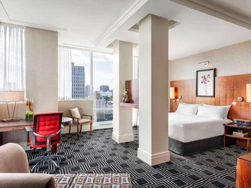 a hotel room with a bed and a desk at Sofitel Montreal Golden Mile in Montréal
