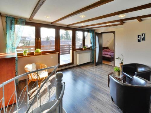 a living room with chairs and a table and some windows at Comfortable holiday home with a garden, Kolobrzeg in Luboszyce