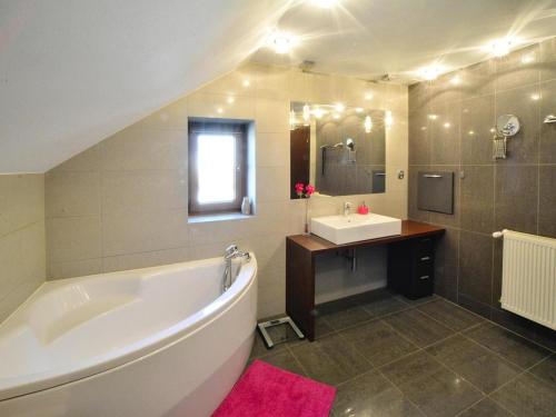 a bathroom with a large tub and a sink at Comfortable holiday home with a garden, Kolobrzeg in Luboszyce