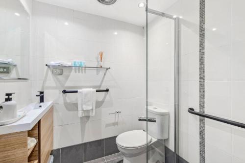 Surf's Up Sawtell في ساوتيل: حمام مع مرحاض ودش زجاجي