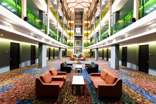 a large lobby with couches and tables in a building at Jazzotel Bangkok in Bangkok