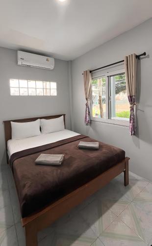a bedroom with a large bed with two towels on it at Gypsy Village Resort in Phi Phi Islands