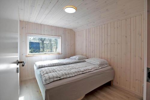 Un dormitorio con una cama en una habitación con ventana. en 10069-Rorvig-Harestykket-3, en Rørvig