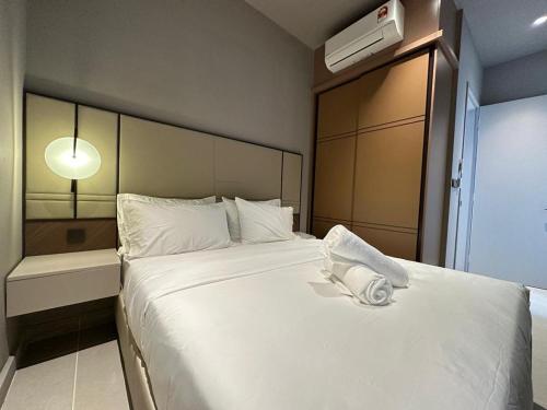 Schlafzimmer mit einem großen weißen Bett und einem Ventilator in der Unterkunft Antara Genting by Enigma 2BR, High Floor in Genting Highlands