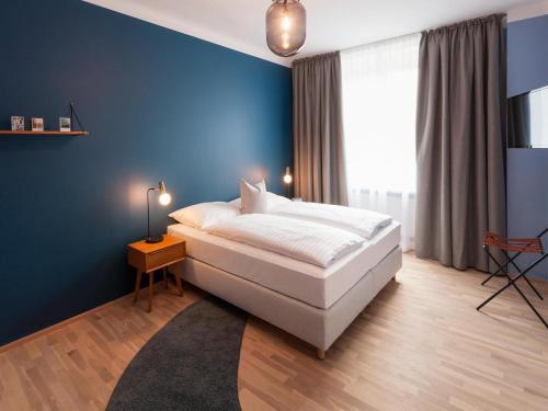 林茨Apartment in Linz near Danube Promenade的卧室里有一张大床，墙壁是蓝色的