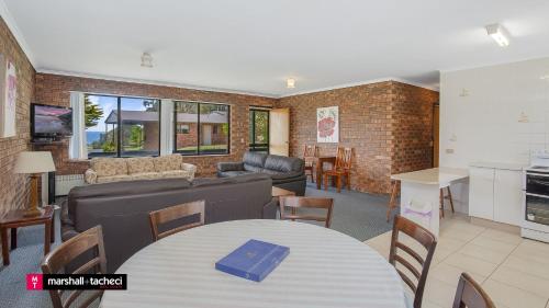 a living room with a couch and a table at Cuttagee Beach Cottage 3 - Tathra Bermagui Rd 3521 in Barragga Bay