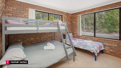 Giường trong phòng chung tại Cuttagee Beach Cottage 2