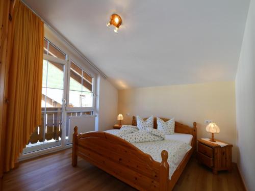 Un dormitorio con una cama y una ventana grande. en Apartment in Zugspitz Arena near Hiking Trails, en Bichlbach