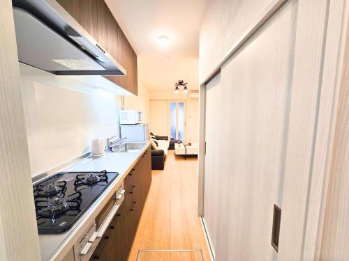 a kitchen with a stove and a counter top at 新大阪ゲストハウス 新大阪駅徒歩5分のリノベーション貸切宿 in Osaka