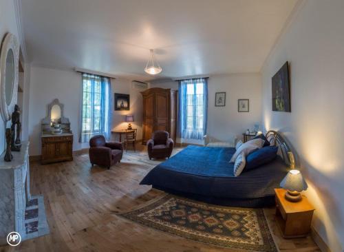 um quarto com uma cama grande e uma sala de estar em Lou Castet de Lussolle - Chambres d'hôtes em Losse