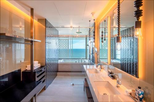 a bathroom with two sinks and a large window at Baba Beach Club Hua Hin Luxury Pool Villa by Sri panwa in Cha Am