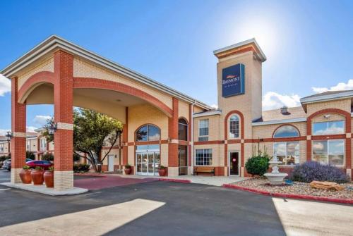 a large brick building with a parking lot at Baymont by Wyndham Lubbock in Lubbock