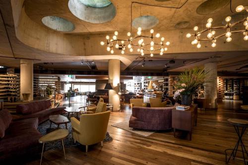 a lobby of a restaurant with couches and chairs at Ovolo Canberra, a Wyndham Hotel in Canberra
