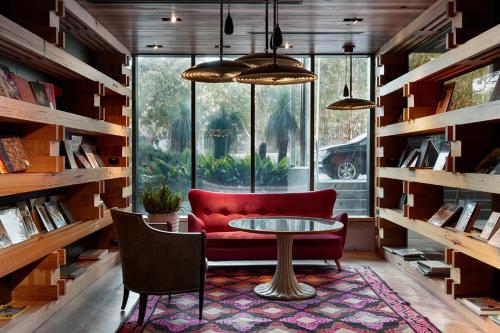 a living room with a red couch and a table at Ovolo Canberra, a Wyndham Hotel in Canberra