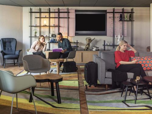 Un grupo de personas sentadas en una sala de estar en Aparthotel Adagio Porte de Versailles, en Issy-les-Moulineaux