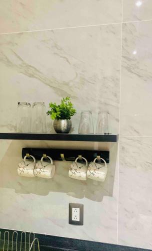 a shelf with glasses and shoes and a clock at Depa de lujo en Acapulco diamante con club de playa a pie-Precio especial in Acapulco