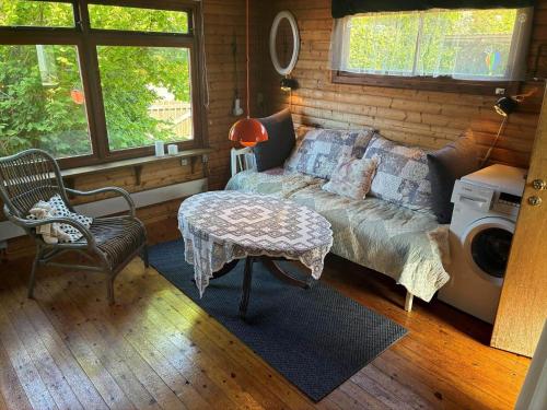 een slaapkamer met een bed, een tafel en een wasmachine bij FJ1003-Jaegerspris-Strandkrogen-2-A in Jægerspris