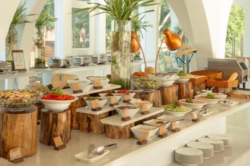 a buffet filled with bowls and plates of food at The Up Hotel Phu Quoc Island - The Poolside Escape in Phu Quoc