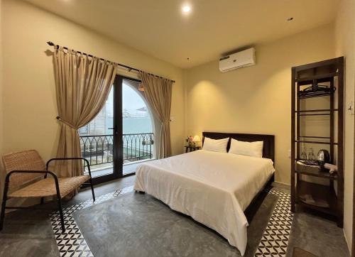 a bedroom with a bed and a window with a view at Nhà thơ Homestay in Cồn Giả Viên