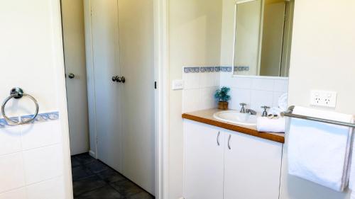 a bathroom with a sink and a mirror at Tanjil Cottage in Lakes Entrance
