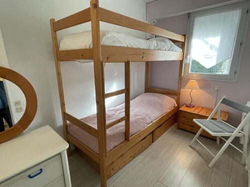 a bedroom with a bunk bed with a desk and a chair at Appartement rez-de-jardin proche Port Crouesty, 4 pers, tennis, piscine, wifi - FR-1-775-50 in Arzon