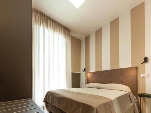 a bedroom with a bed and a large window at Alba Adriatica apartments charm in Alba Adriatica