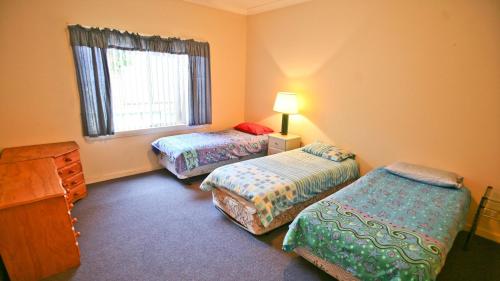 una stanza con due letti e una finestra di Fisherman's Cabin - 11 Mill Street Affordable, fishing friendly a Bermagui