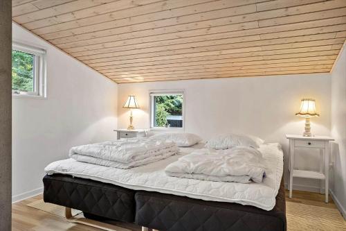 uma cama grande num quarto com tecto em madeira em LF15195-Hojslev-Sneppevej-25 em Nørre Ørum