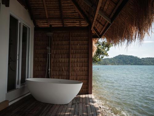 a bath tub sitting on a deck next to the water at Sunstone Koh Chang in Ko Chang