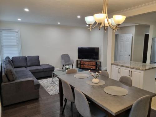 a kitchen and living room with a table and a couch at Newly Renovated 3BR Upper Unit - Bright & Quiet in Richmond Hill