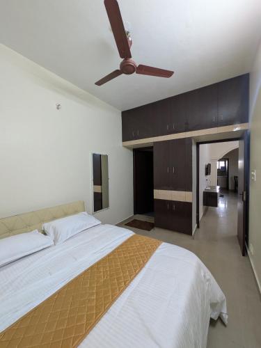 a bedroom with a bed with a ceiling fan at Sri Abirami Homestays in Tiruvannāmalai