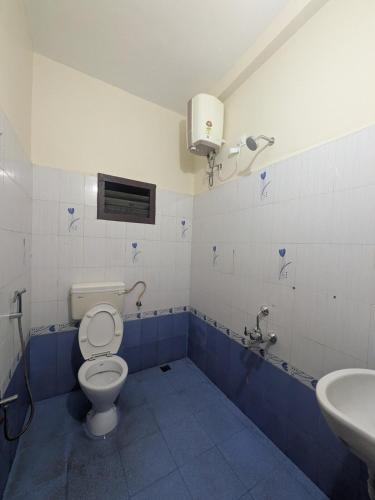 a bathroom with a toilet and a sink at Sri Abirami Homestays in Tiruvannāmalai