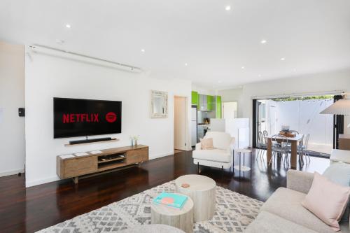 a living room with a tv on a wall at Home Away From Home - Maribyrnong Boutique Townhouse in Maribyrnong