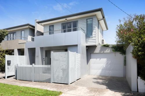 a house with a white fence in front of it at Home Away From Home - Maribyrnong Boutique Townhouse in Maribyrnong