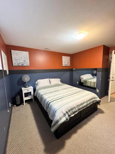 a bedroom with a large bed with an orange wall at Peaceful House with Backyard in Langley
