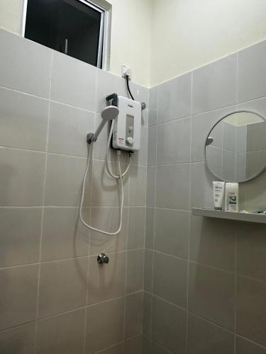 a shower in a bathroom with a mirror at NHI Home Paka in Paka