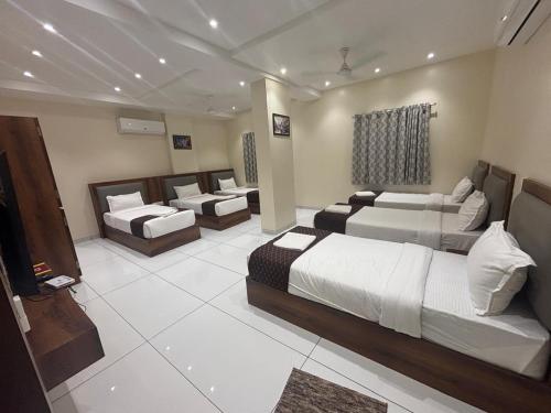 TuljapurThe Skyland Hotel And Restaurant的酒店客房,带三张床