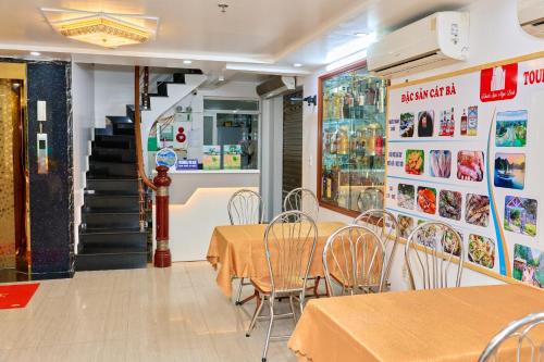 Un comedor con mesas y sillas y una escalera. en Ngoc Linh Hostel and Travel, en Cat Ba