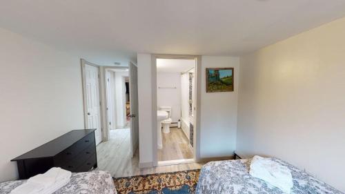 Habitación blanca con 2 camas y baño. en Winter Lore, en Mendon