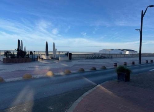 an empty street with a view of the beach at Residentie Peter Pan in Knokke-Heist