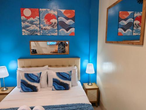 una camera da letto con pareti blu e un letto con due lampade di The Cat And The Kraken Paliton Jacuzzi Suites with Solar and Starlink a Siquijor