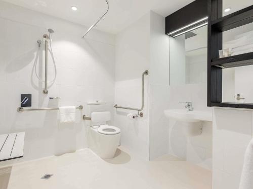 Un baño blanco con inodoro y lavabo. en ibis Adelaide, en Adelaida