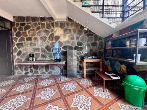 una cucina con parete in pietra e pavimento piastrellato di Mandalas Hideout a San Pedro La Laguna