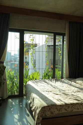 a bedroom with a bed and a large window at Soda Boutique Apartment Danang in Danang