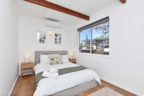 Postel nebo postele na pokoji v ubytování The Jacaranda - Pet Friendly, Air-Con, Wifi, Boat Parking, Large backyard